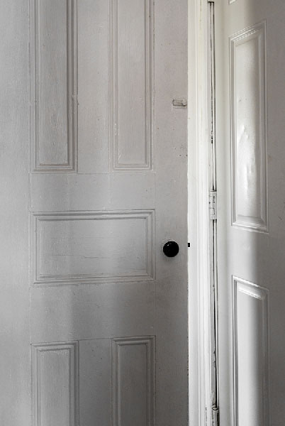 20" x 30" Archivla Inkjet Print. Corner of two white doors, one ajar. Light spilling in. Color Photograph.